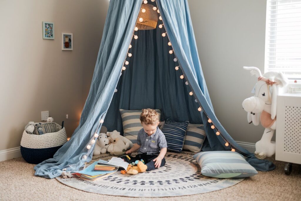 Cozy corner of a toddler boy's room with a simple DIY canopy made