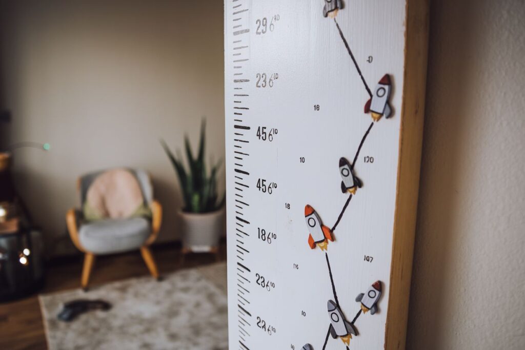 Wooden board diy growth chart mounted on a bedroom wall